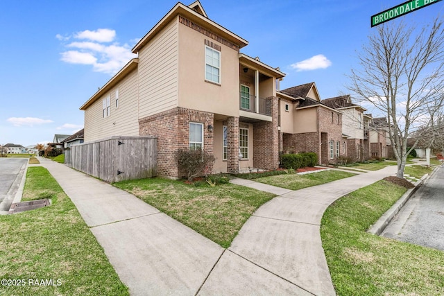 view of home's exterior with brick siding, a residential view, and a lawn