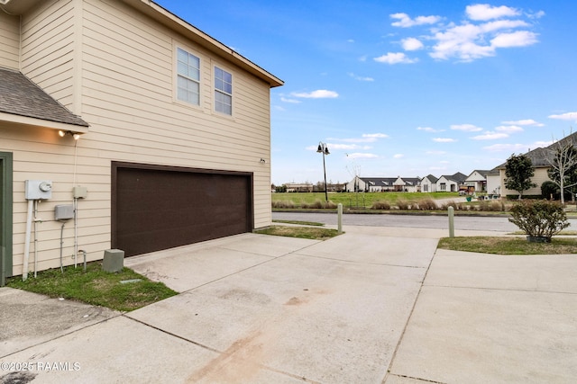 view of side of home with a garage and driveway