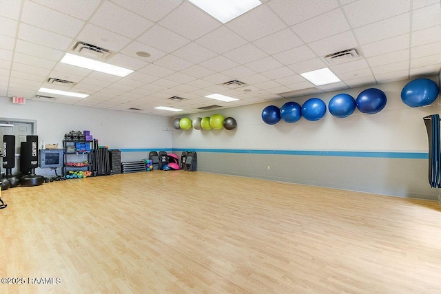 exercise room featuring visible vents, a paneled ceiling, and wood finished floors