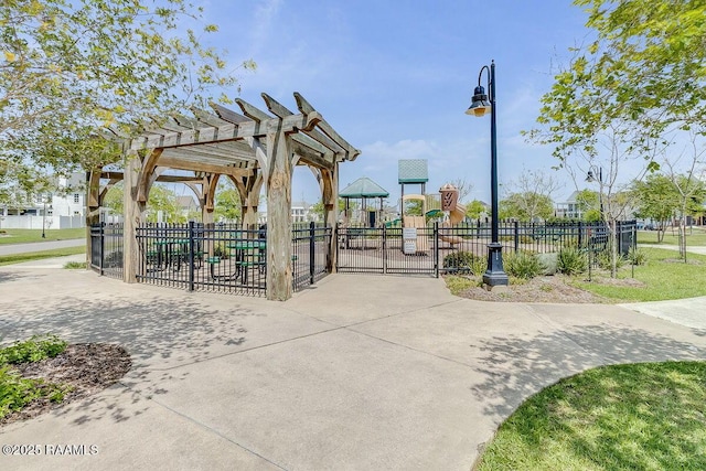 view of home's community featuring a pergola, playground community, and fence