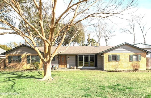 single story home featuring roof with shingles, brick siding, a chimney, and a front lawn