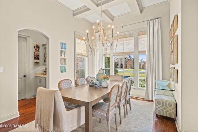 dining space featuring coffered ceiling, dark wood-style floors, beam ceiling, crown molding, and a notable chandelier