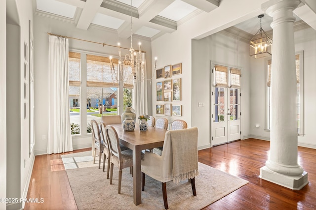 dining space with a healthy amount of sunlight, ornate columns, and a chandelier