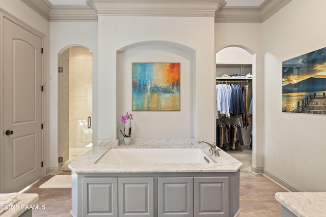 full bathroom with a garden tub, crown molding, a shower stall, and wood finished floors