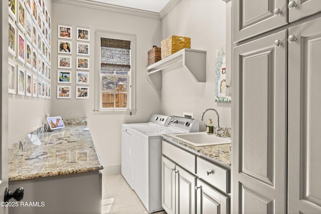 laundry room with washing machine and clothes dryer, light tile patterned floors, cabinet space, ornamental molding, and a sink