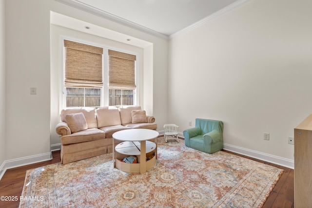 living area with wood-type flooring, crown molding, and baseboards