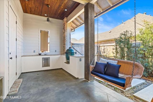 view of patio / terrace with fence, an outdoor kitchen, and area for grilling