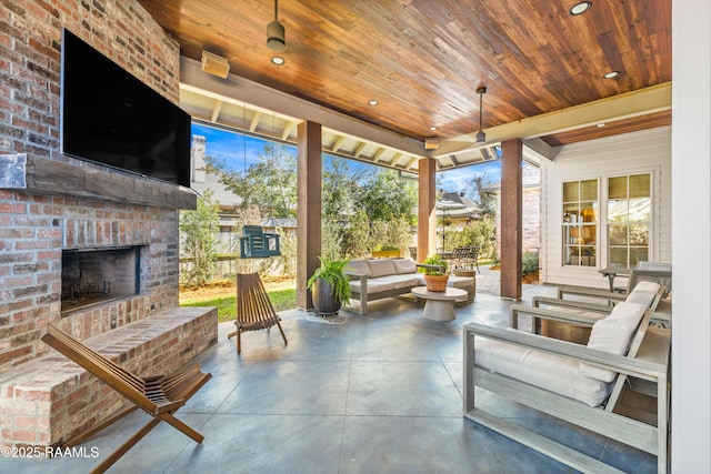 sunroom with an outdoor brick fireplace and wood ceiling