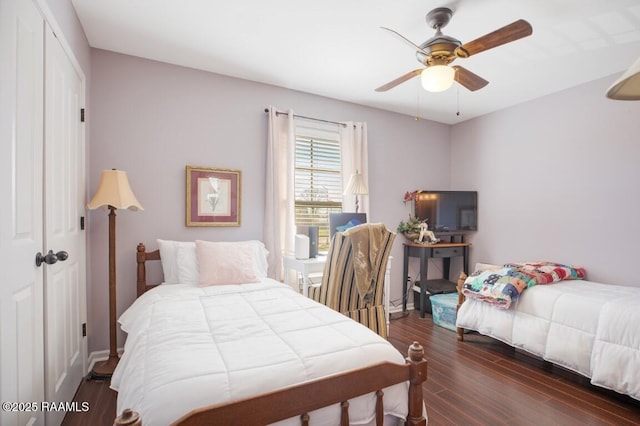 bedroom with ceiling fan, a closet, wood finished floors, and baseboards