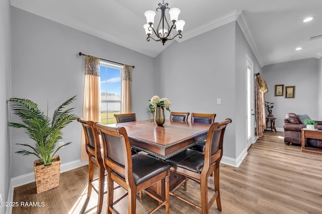 dining area with light wood-type flooring, baseboards, and a notable chandelier