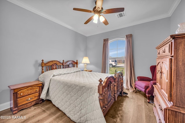 bedroom with light wood finished floors, a ceiling fan, visible vents, and crown molding