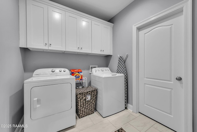 washroom featuring cabinet space, marble finish floor, and washer and dryer