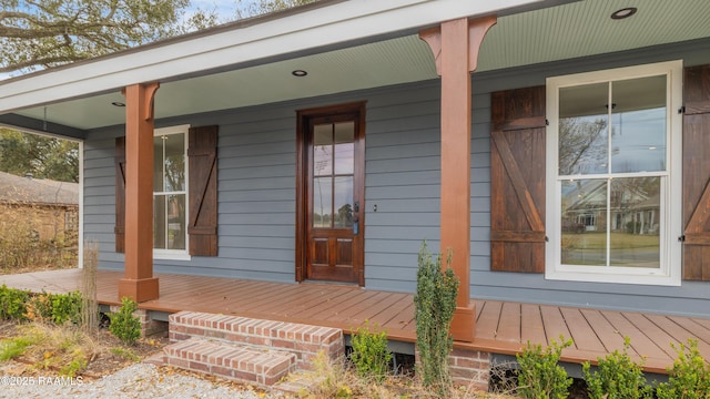 view of exterior entry with covered porch and a standing seam roof