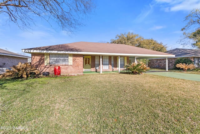 ranch-style home with brick siding, an attached carport, a front lawn, covered porch, and driveway