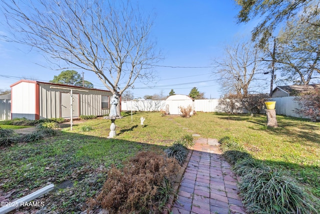 view of yard featuring a shed, an outdoor structure, and a fenced backyard