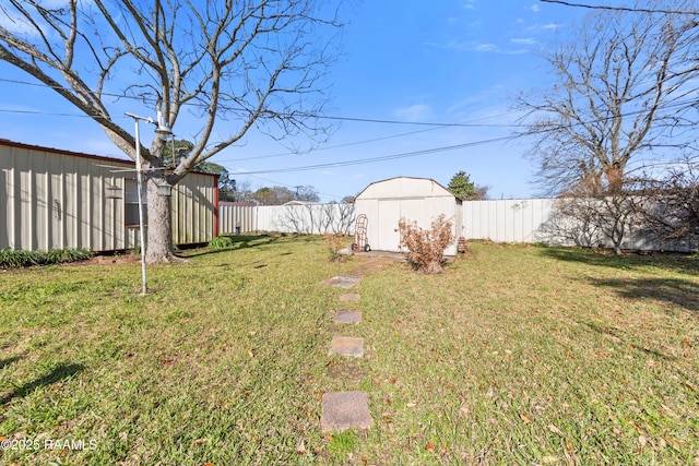 view of yard featuring a storage unit, an outdoor structure, and a fenced backyard