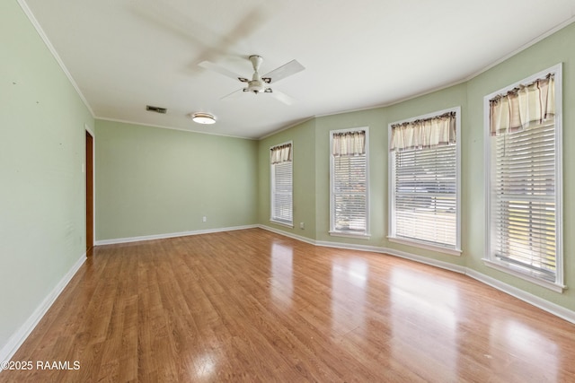 unfurnished room featuring wood finished floors, baseboards, visible vents, ceiling fan, and ornamental molding