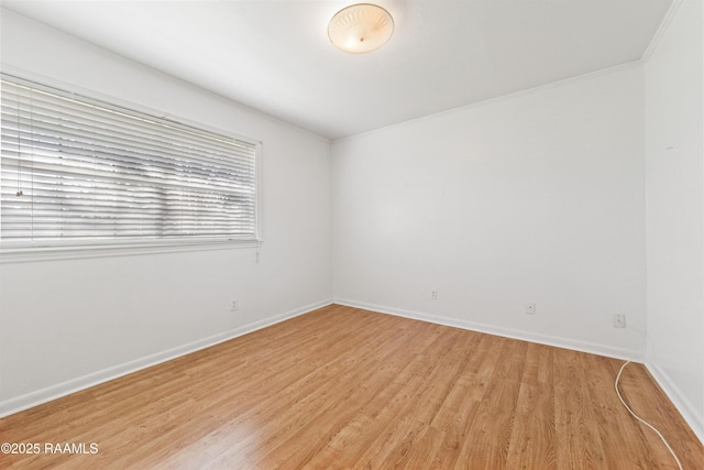 unfurnished room with light wood finished floors, crown molding, and baseboards