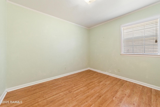 spare room with light wood-type flooring, baseboards, and ornamental molding