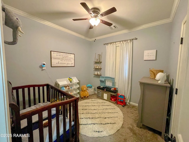 carpeted bedroom featuring crown molding, visible vents, a ceiling fan, a crib, and baseboards