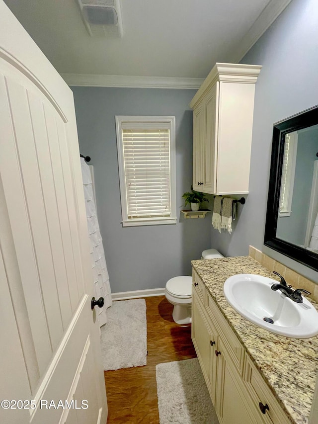 full bathroom with toilet, wood finished floors, vanity, baseboards, and ornamental molding