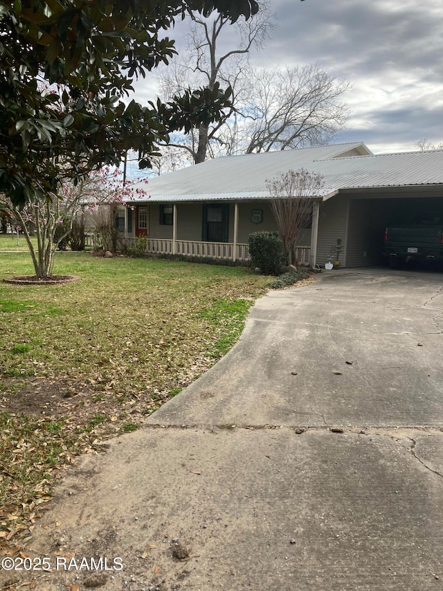 ranch-style home featuring metal roof, concrete driveway, and a front yard