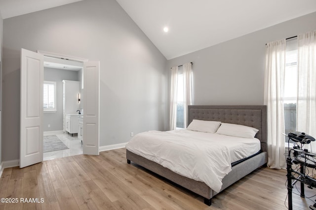 bedroom with high vaulted ceiling, light wood-type flooring, and baseboards