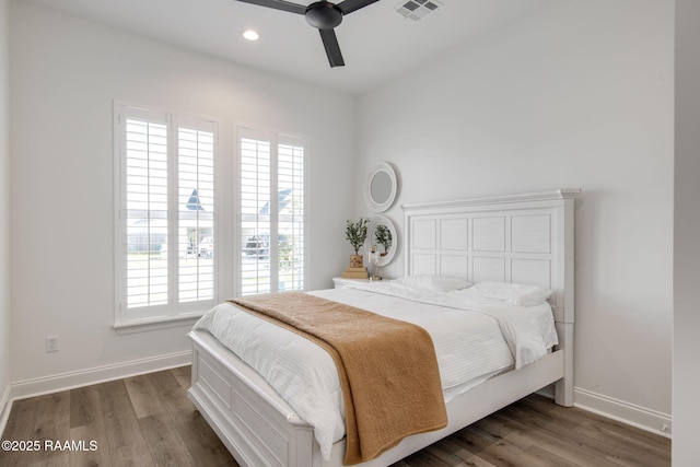 bedroom featuring baseboards, visible vents, and wood finished floors