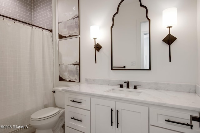 bathroom with curtained shower, vanity, and toilet