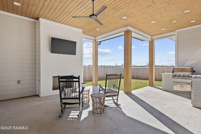 view of patio / terrace with exterior kitchen, a grill, a ceiling fan, and fence