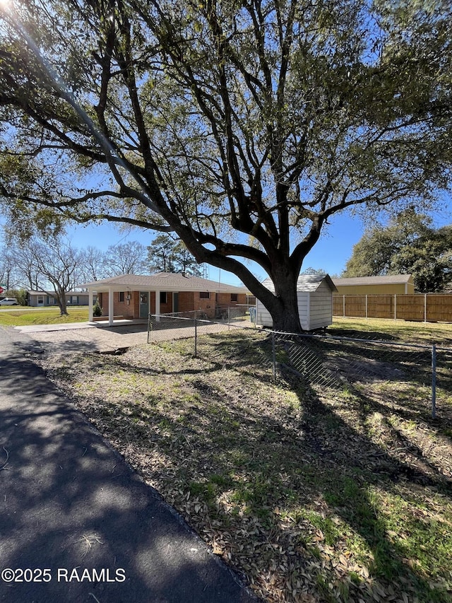 exterior space with fence, an outdoor structure, and a shed