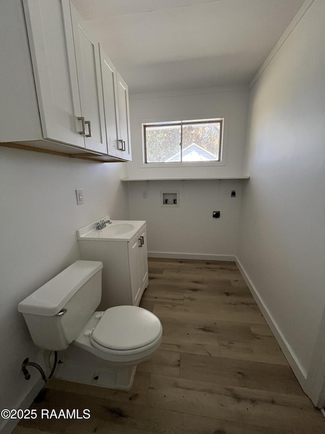 bathroom with baseboards, vanity, toilet, and wood finished floors