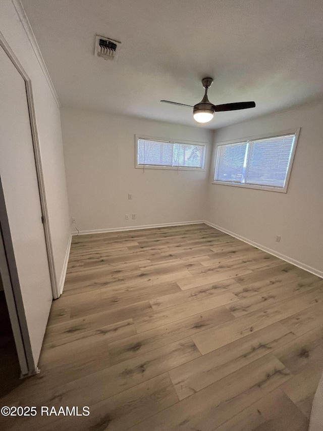 unfurnished bedroom with light wood-style floors, visible vents, ceiling fan, and baseboards