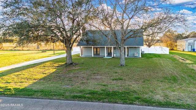 view of front of property with covered porch, fence, and a front lawn