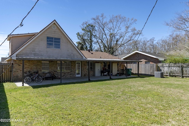 back of property with a fenced backyard, cooling unit, a yard, a patio area, and brick siding