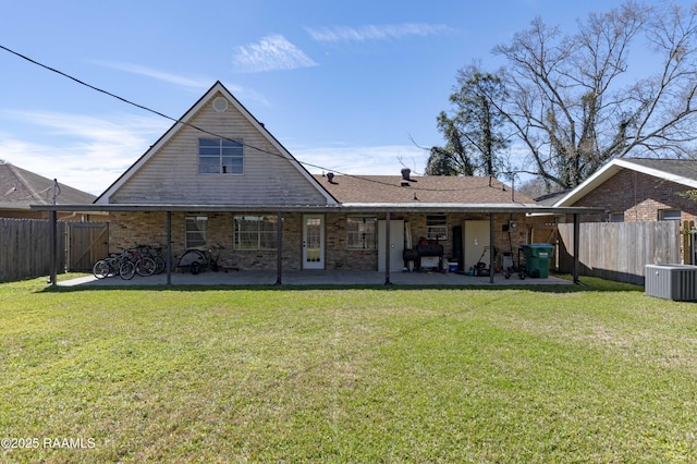 rear view of house with a yard, a fenced backyard, brick siding, and a patio