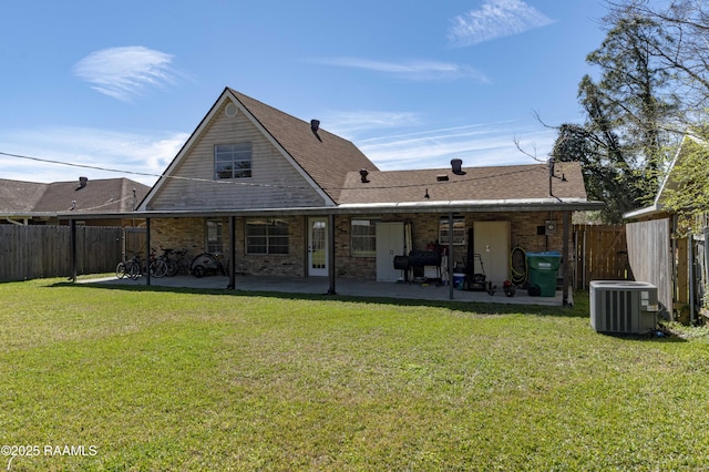 rear view of property with a patio area, a fenced backyard, central AC unit, and a lawn