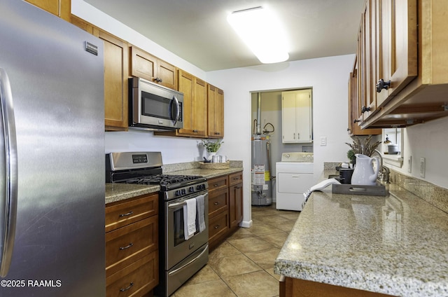 kitchen with appliances with stainless steel finishes, brown cabinets, washer / clothes dryer, gas water heater, and light tile patterned flooring