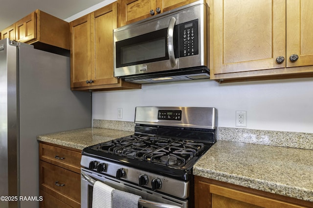 kitchen with brown cabinets, appliances with stainless steel finishes, and light countertops