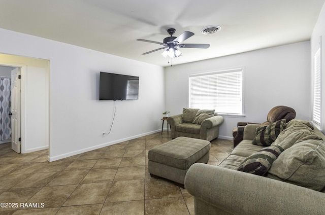 tiled living room featuring visible vents, ceiling fan, and baseboards