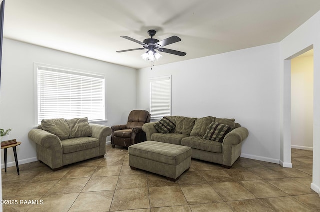 living room featuring a ceiling fan, baseboards, and light tile patterned floors