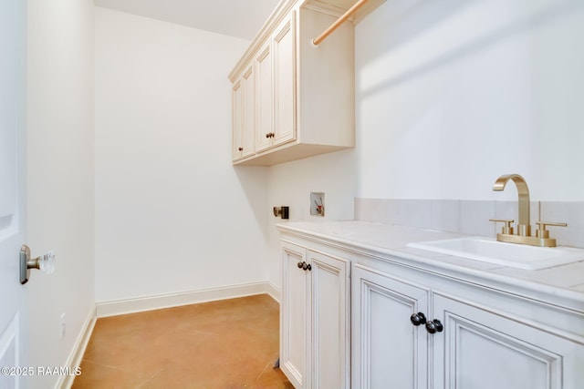 laundry room with washer hookup, a sink, cabinet space, and baseboards