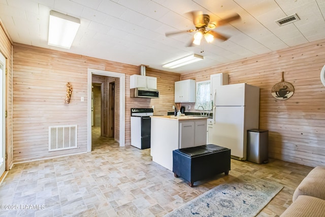 kitchen with range with electric cooktop, freestanding refrigerator, visible vents, and stainless steel microwave