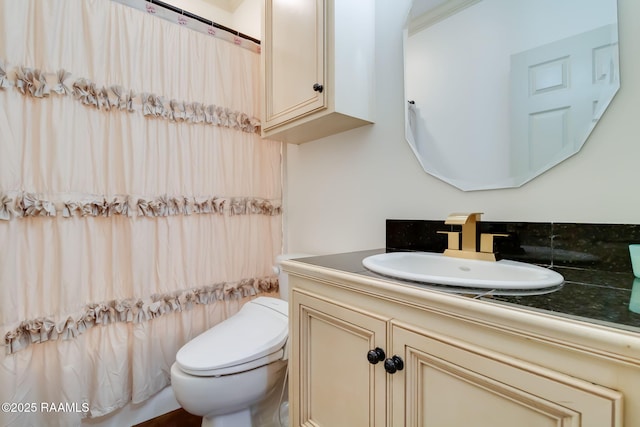 full bath with curtained shower, vanity, and toilet