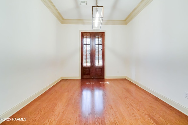 entrance foyer with ornamental molding, wood finished floors, visible vents, and baseboards