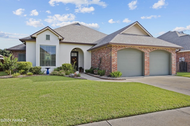 view of front of home featuring driveway, a shingled roof, a front lawn, and brick siding