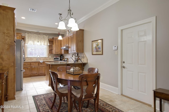 dining area featuring light tile patterned floors, baseboards, visible vents, and crown molding