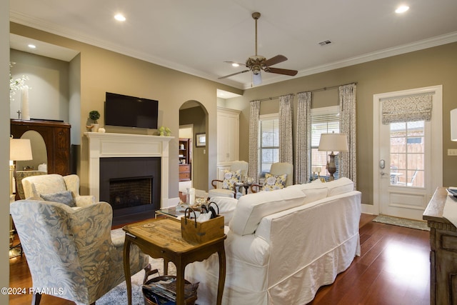 living area featuring visible vents, a fireplace with flush hearth, dark wood-style flooring, crown molding, and recessed lighting