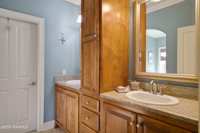 full bath featuring double vanity, crown molding, and a sink