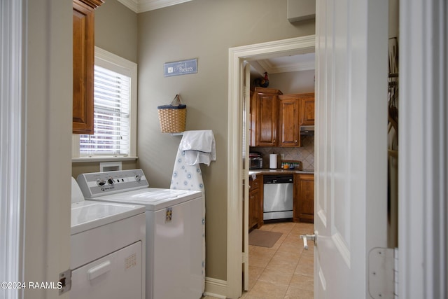 laundry room with washer and dryer, cabinet space, crown molding, and light tile patterned flooring